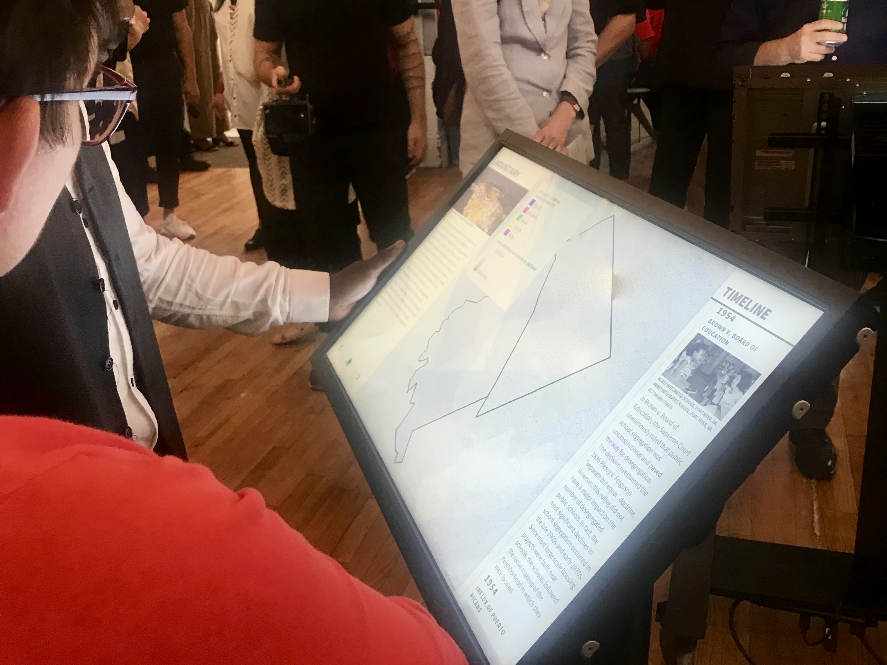 Exhibit visitors walk through the history of redlining in Mount Airy with maps provided by Azavea